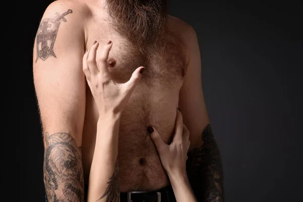 黑暗背景下的纹身男子与他的女朋友 — 图库照片