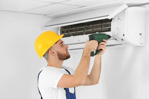 Technician fixing air conditioner — Stock Photo, Image