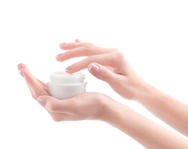Young woman holding jar of hand cream on white background