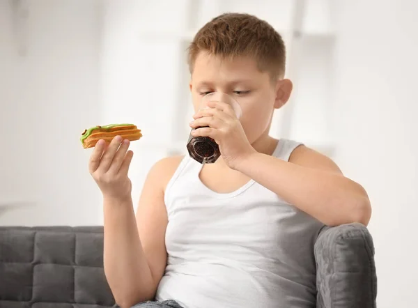 Overweight Boy Eating Eclair Drinking Cola Home — Stock Photo, Image