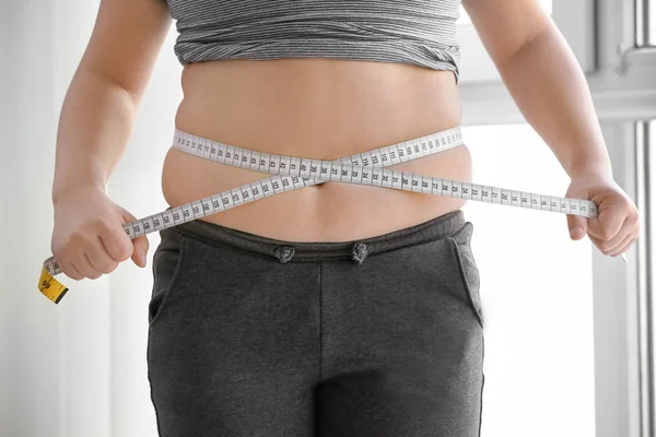 Overweight boy measuring waist — Stock Photo, Image