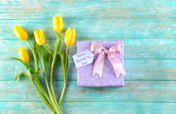 Composition with gift box and flowers for Mother\'s Day on color wooden background