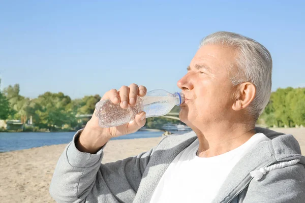 Mature man drinking water — Stock Photo, Image