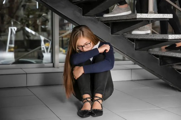 Ideges tizenéves lány ül a padló alatt beltéri lépcsők — Stock Fotó