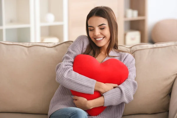 Mujer joven con almohada en forma de corazón —  Fotos de Stock