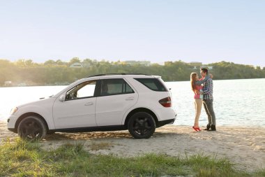 Nehir kıyısında car yakınındaki ayakta genç Çift