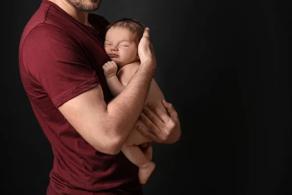 Père avec mignon petit bébé sur fond sombre — Photo