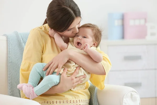 若い母親は家に彼女のかわいい小さな赤ちゃんにキス — ストック写真