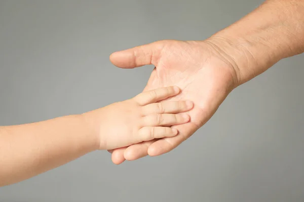 Mãos Homem Idoso Bebê Sobre Fundo Cinza Claro — Fotografia de Stock