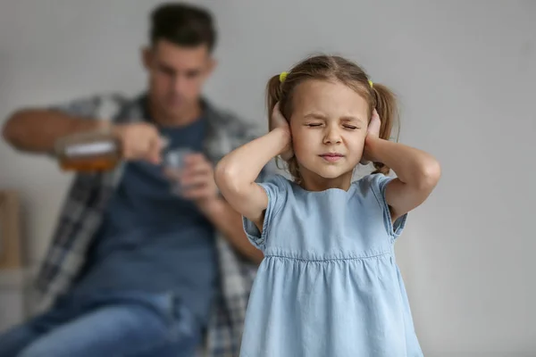 Küçük kız Kapak kulakları ve onu içme alkol arka plan baba — Stok fotoğraf