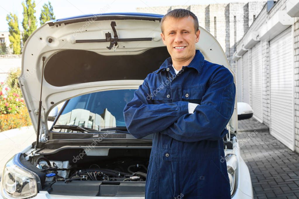 Auto mechanic standing near car outdoors