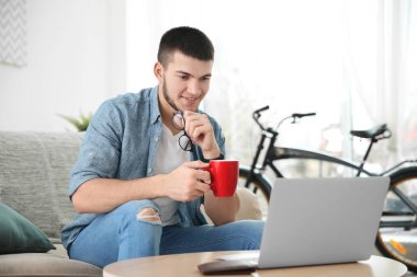 Genç adam dizüstü bilgisayar kullanıyor 