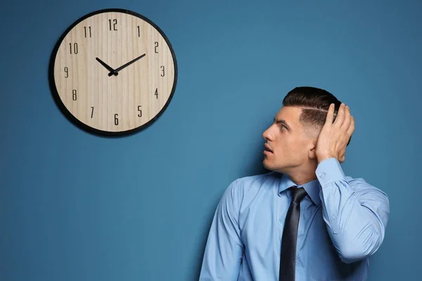 Shocked manager looking at clock