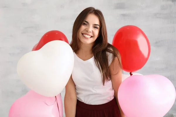 Ung kvinna med hjärtformade ballonger — Stockfoto