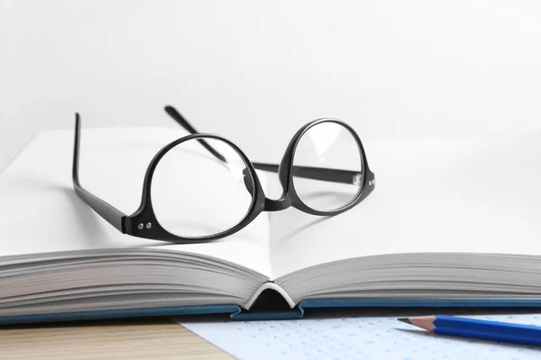 Open notebook with students eyeglasses — Stock Photo, Image