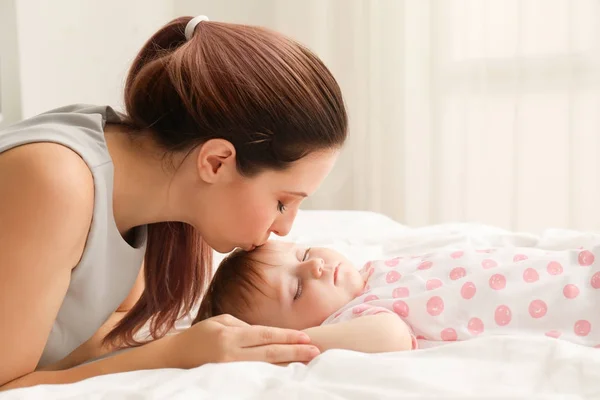 若い母親は家で眠っている赤ん坊をキス — ストック写真