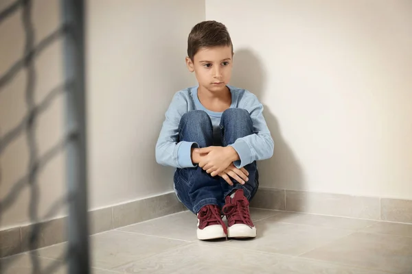 Маленький хлопчик сидить на підлозі в приміщенні — стокове фото