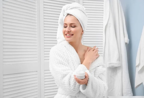 Mujer joven usando producto cosmético —  Fotos de Stock