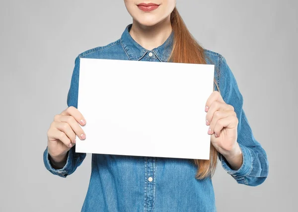 Νεαρή Γυναίκα Κενό Φύλλο Χαρτιού Για Διαφήμιση Γκρι Φόντο Κοντινό — Φωτογραφία Αρχείου