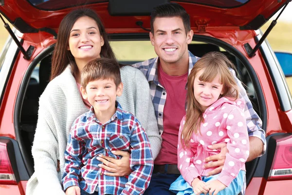 Счастливая семья рядом с машиной — стоковое фото