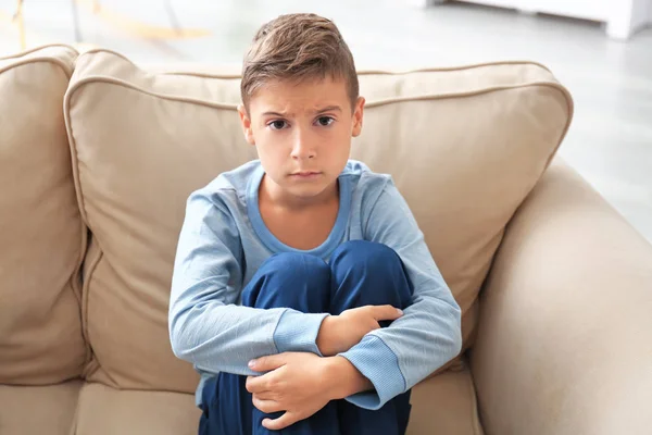 Depressed little boy on couch at home — Stock Photo, Image