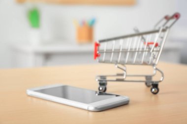 Cep telefonu ve masada küçük araba. Internet alışveriş kavramı