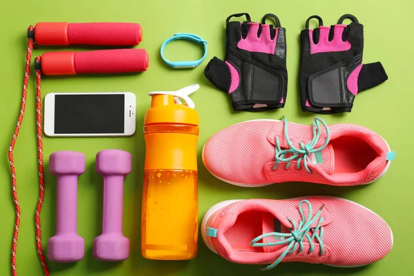Sport stuff for gym and mobile phone on color background, flat lay