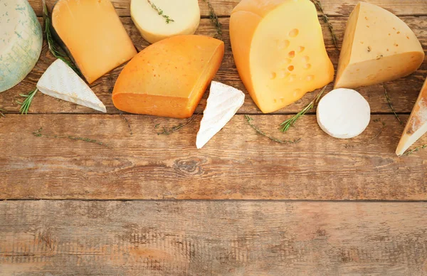 Variety of cheese on wooden background