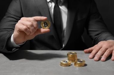 Adam altın bitcoins masadan, closeup ile