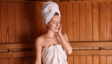 Sauna ahşap bankta oturan genç kadın