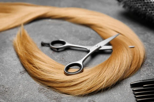 Professionelle Friseurschere Und Strähne Blonde Haare Auf Grauem Hintergrund — Stockfoto