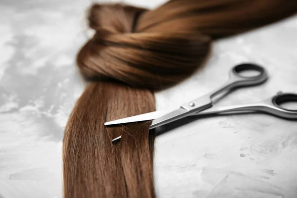 Professionelle Friseurschere Und Strähne Braune Haare Auf Grauem Hintergrund — Stockfoto