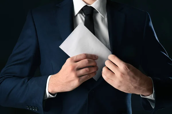 Geschäftsmann Steckt Umschlag Mit Bestechungsgeld Tasche Auf Schwarzem Hintergrund — Stockfoto