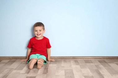 Renk duvara yakın oturan sevimli küçük çocuk