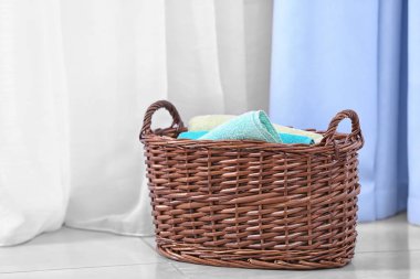 Brown laundry basket with towels indoors