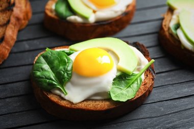 Kızarmış yumurta ve ahşap tahta üzerinde avokado lezzetli bruschetta