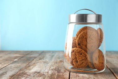 Cam ahşap masa üzerinde çikolata parçaları ile lezzetli yulaf ezmeli kurabiye