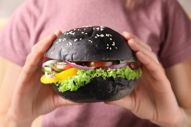 Lezzetli siyah hamburger, closeup tutan kadın