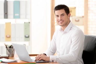 Genç adam ofiste çalışıyor.