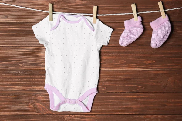 Barnkläder Tvätt Linje Mot Trä Bakgrund — Stockfoto