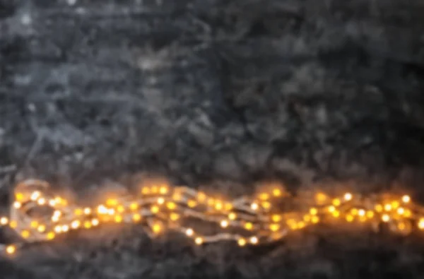 灰色の背景に光るクリスマス ライトのビューをぼかします — ストック写真