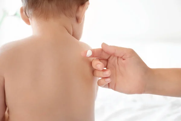 Woman Applying Body Cream Her Baby Light Background — Stock Photo, Image