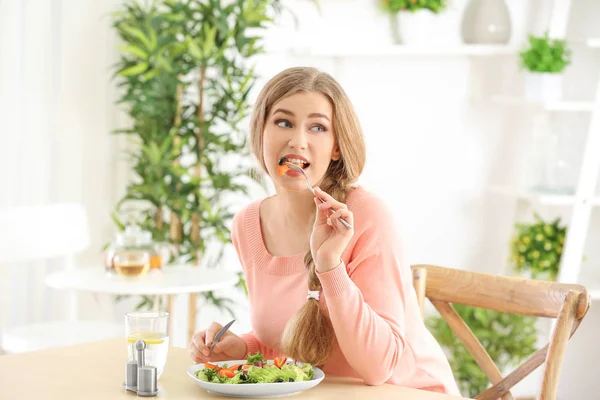 Giovane bella donna mangiare insalata fresca a casa — Foto Stock