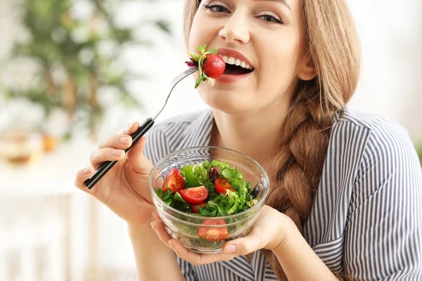 Jovem mulher bonita comendo salada fresca em casa — Fotografia de Stock