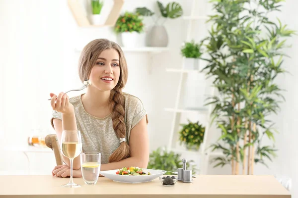 Jovem mulher bonita comendo salada fresca em casa — Fotografia de Stock