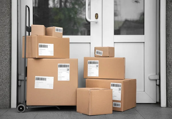 Postal cart with delivered parcels near front door