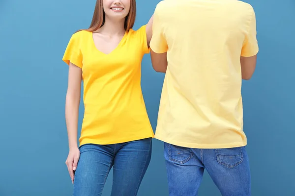 在颜色背景的黄色 T恤衫的年轻妇女和人 设计样机 — 图库照片