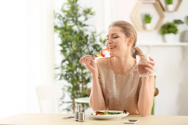 Giovane bella donna mangiare insalata fresca a casa — Foto Stock