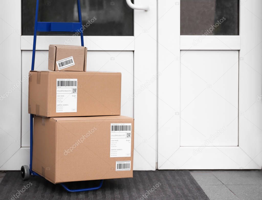 Postal cart with delivered parcels near front door