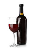 Láhve a sklenice s červeným vínem na světlé pozadí